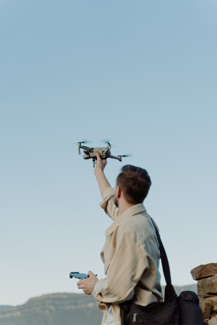 Home A man launches a drone in a scenic outdoor location, perfect for adventure or tech themes.