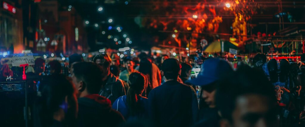 pexels photo 1472334 1472334 A bustling street market at night with crowds and vibrant streetlights.