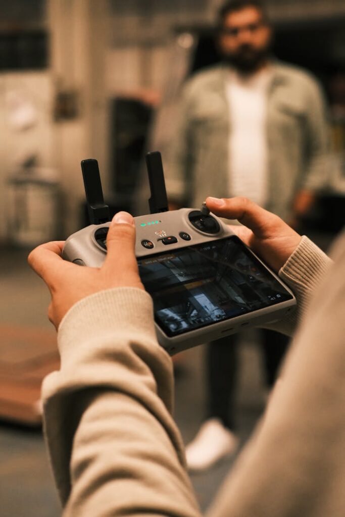 pexels photo 29224627 A person holds a remote controller for a drone in an indoor setting with blurred background.